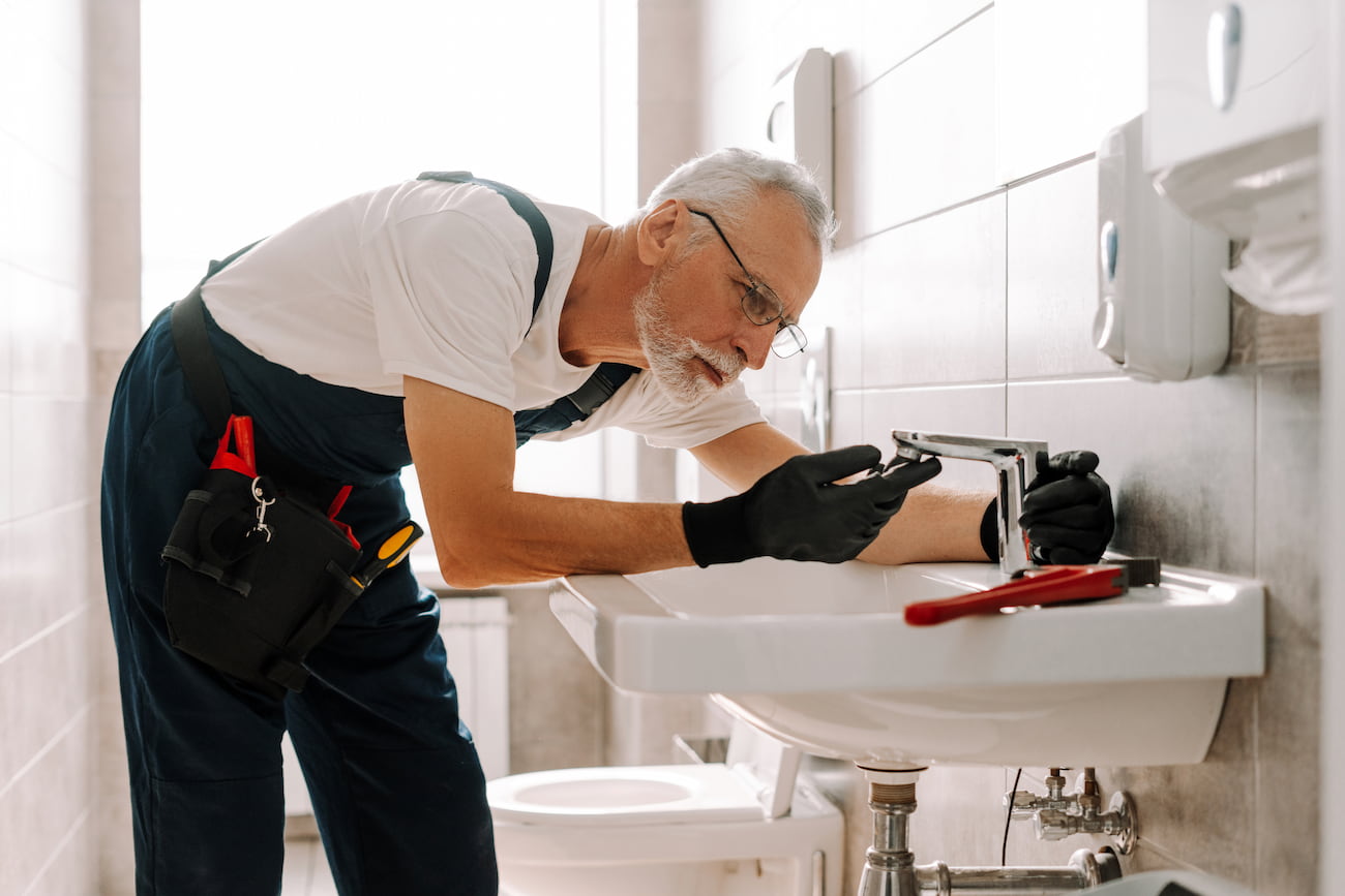 Fontanero cambiando el cartucho de un grifo monomando en baño moderno